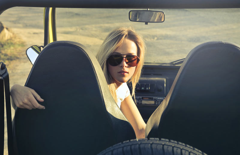Una chica lleva gafas de sol mientras conduce